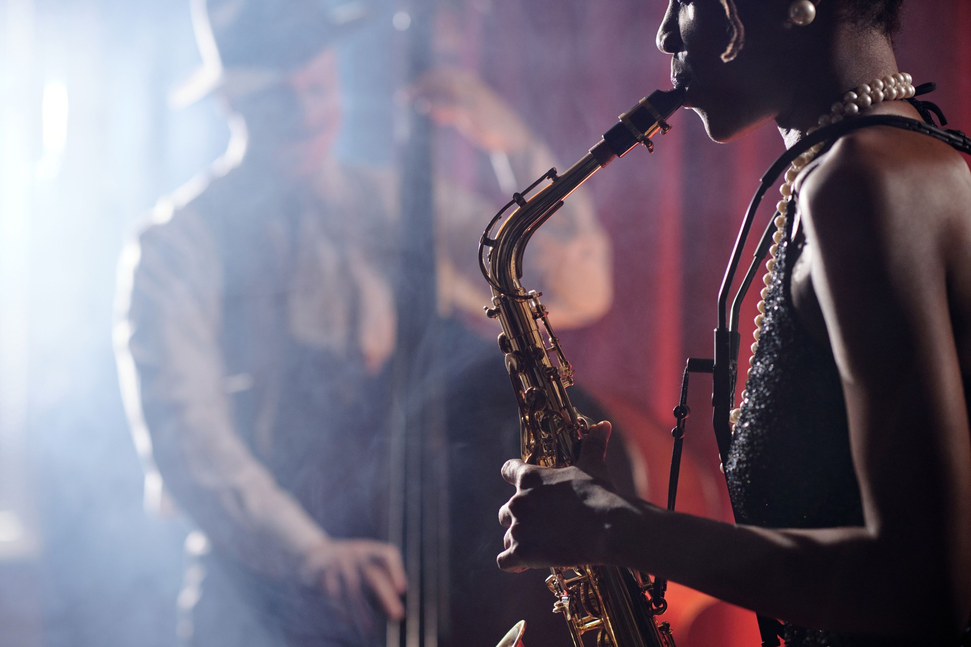 Young Adult Black Woman Playing Saxophone with Jazz Musicians Performing Live